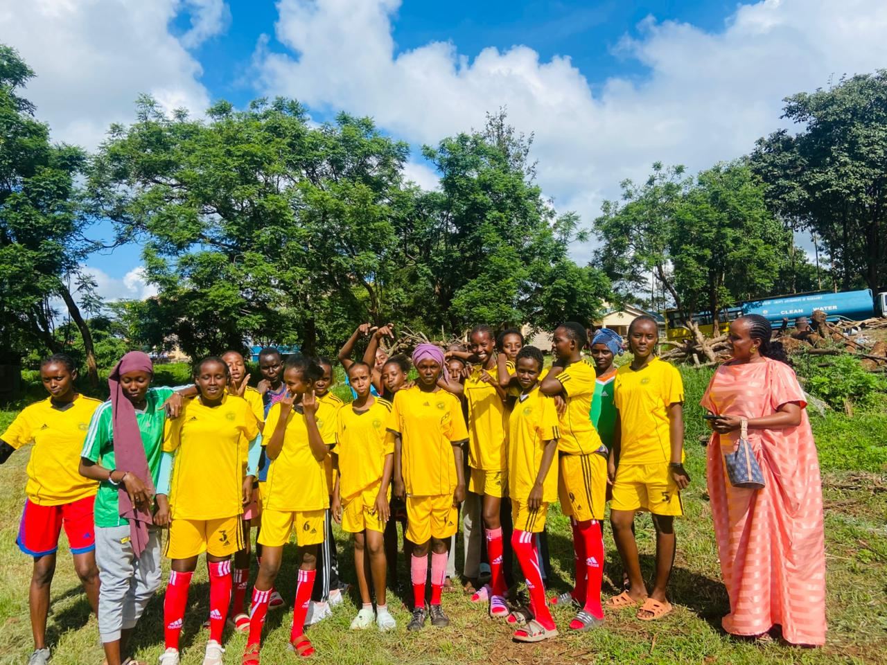 Girls' football team with their coach, casual group photo