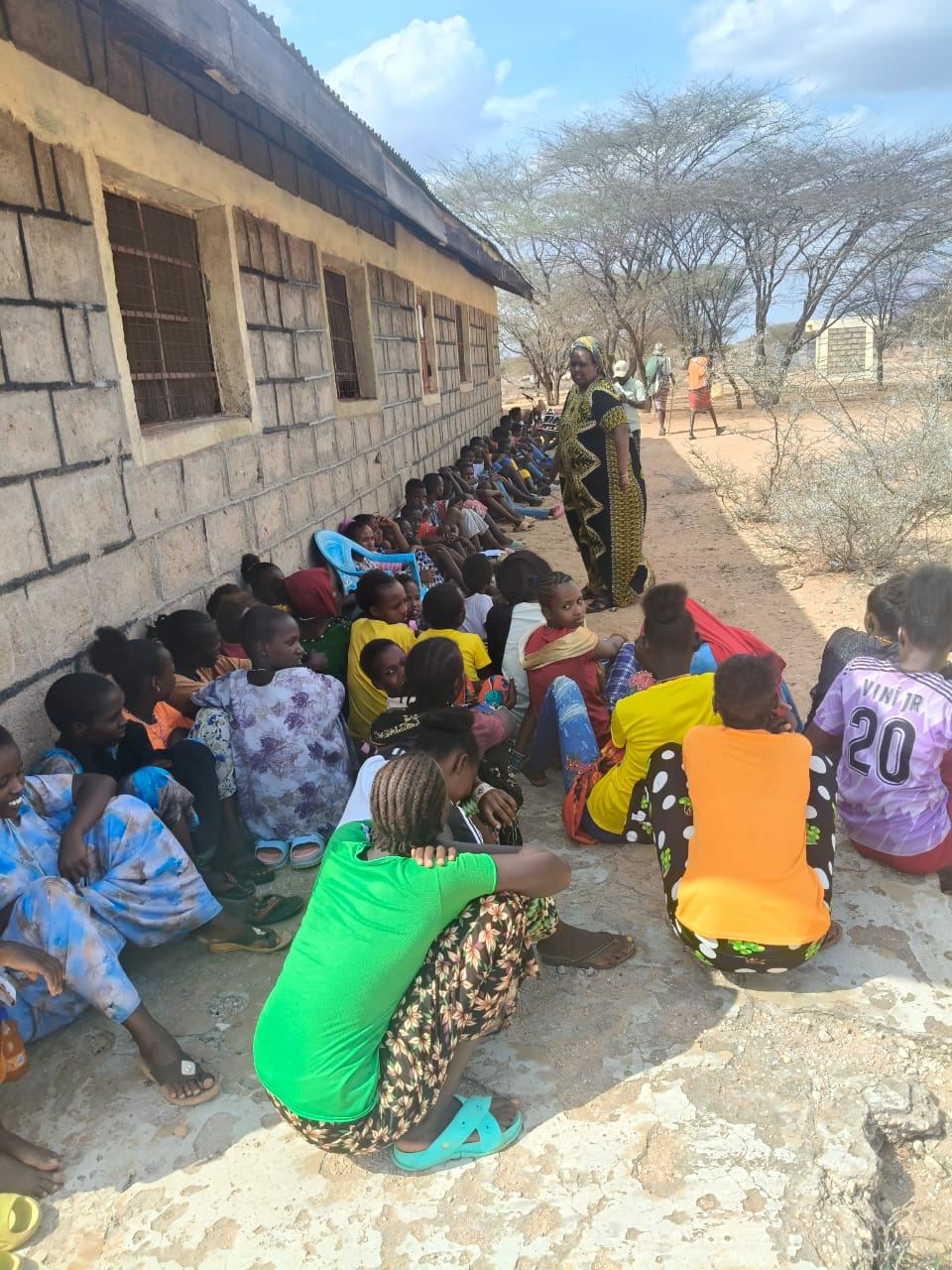 Girls seated outside a school compound in Laisamis