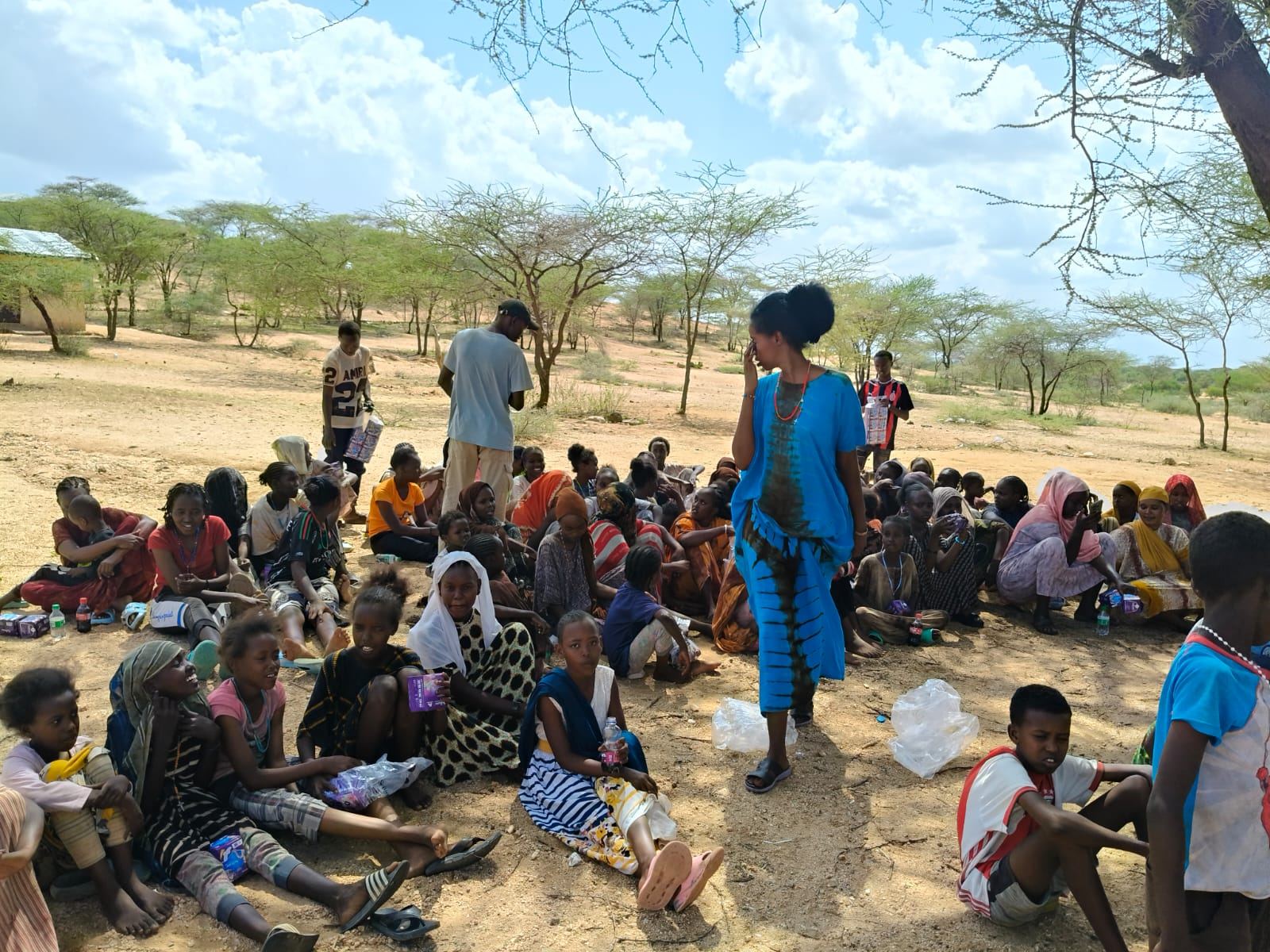 FAN staff distributing supplies to girls and children outdoors